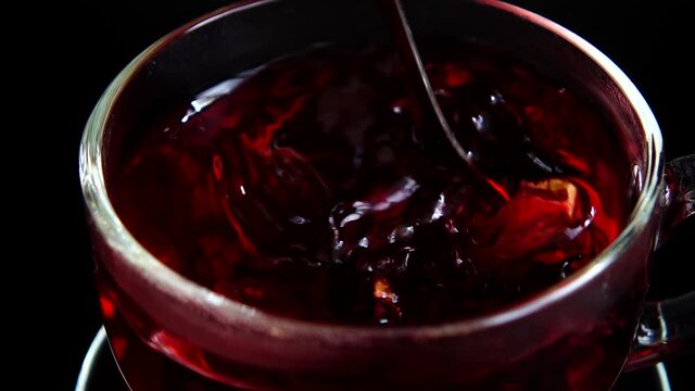 Preparation of Hibiscus tea in a glass cup.
