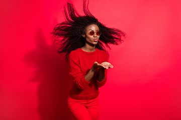 Photo of pretty adorable dark skin woman dressed casual pullover sending kiss arms empty space...