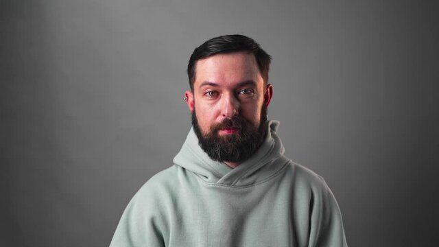 Slow motion Portrait of bearded man moving his eyebrows on grey background
