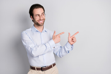 Portrait of attractive cheerful man specialist demonstrating copy space ad advert isolated over grey pastel color background