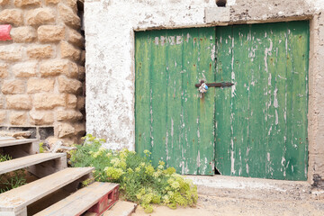 Green wooden gate of a coastal barn for boats