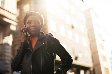 Fototapeta premium : Young african woman using the phone. Beautiful woman talking to the phone.