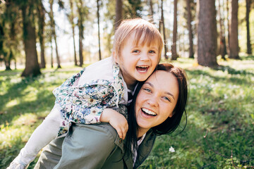 Happy mother smiling with little kid daughter. Single woman playing with preschool children. Family...
