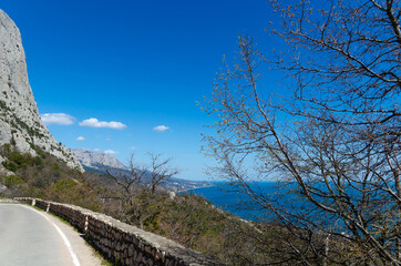 Picturesque mountain summer landscape with sea views. A winding road at the foot of a mountain, Crimea. Travel and vacation concept.