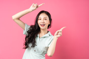 Young Asian woman pointing upwards with cheerful face