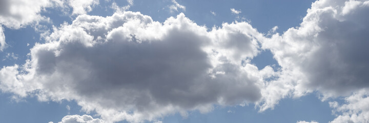 blue sky with white clouds backlit by sunlight