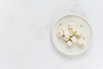 Tofu cheese with micro greens on a plate. Horizontal orientation, copy space.