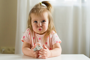 Little expressive girl playing theater with animal finger puppets. Role-playing games and...