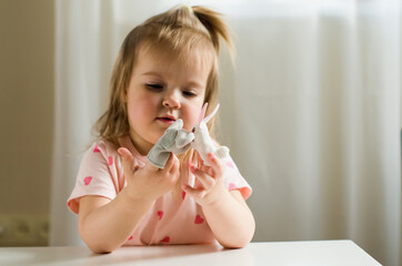 Little expressive girl playing theater with animal finger puppets. Role-playing games and...