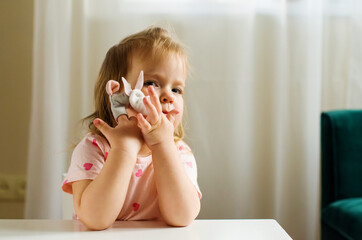Little expressive girl playing theater with animal finger puppets. Role-playing games and...