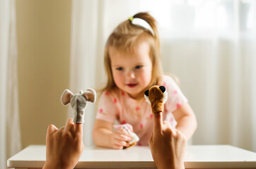 Child playing theater with animal finger puppets. Role-playing games and activities for expressing...