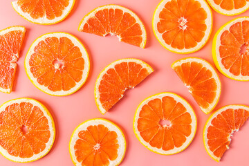 Group of fresh organic grapefruit slices over pink background. Flat lay.