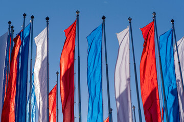 White, blue, red flags as Russian flag in total. Imitation flag of Russia in a street during warm sunny day.