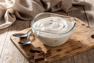 Stracciatella yogurt in transparent bowl on wooden table