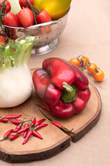 Fresh and various vegetables, peppers fennel celery and tomatoes on a wooden table. White background. Vertical view from top