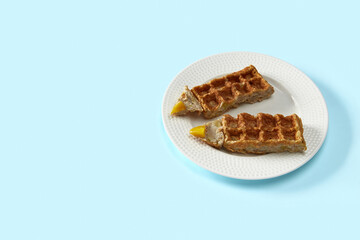 Oatmeal Belgian waffles in pencil shape on blue table