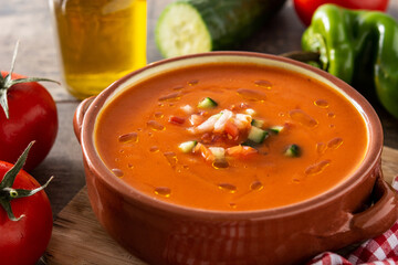 Gazpacho soup in crock pot and ingredient on wooden table