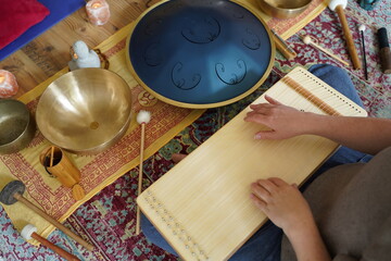 Caucasian woman holding a monochord, sound healing instrument in a therapy session, hands close up.