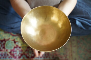 Caucasian woman holding a Tibetan singing bowl in her hand for sound healing therapy 