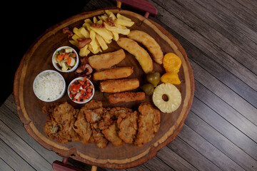 Cuban filet. Made with breaded Steak, cheese, breaded ham and banana, Vinaigrette, white rice, pineapple and Fig. Top view photo with space for text.