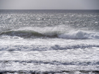 Breaking waves and seaspray, no land, Bad weather sea background. UK grey.