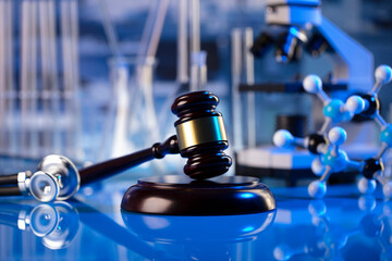 Medical law concept. Gavel and stethoscope on the glass table. Blue light.