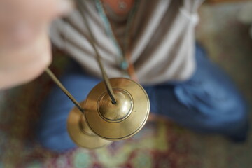 Close up female hands playing cymbals for sound healing therapy