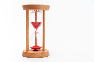 Old hourglass with red sand. Isolated on a white background. Close up. Copy space.