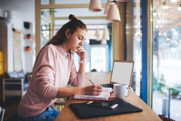 Fototapeta premium Wistful woman with planner working in cafe