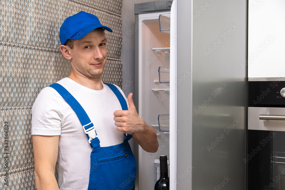 Wall mural uniformed repairman smiles, looks at the camera, and gives a thumbs-up sign against the backdrop of 