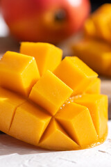 Diced fresh mango fruit on a white plate with leaves.