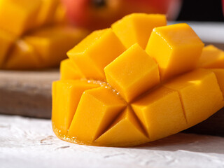 Diced fresh mango fruit on a white plate with leaves.