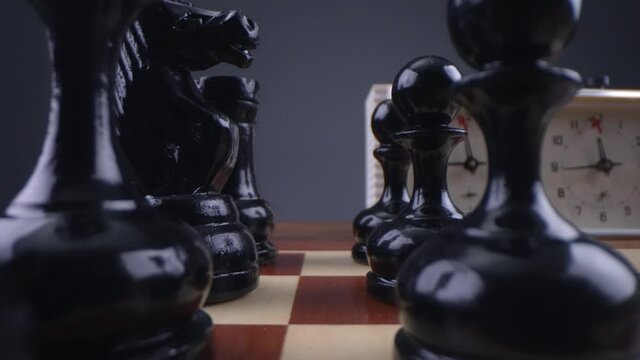 Look between the chess pieces. Two chess players man and woman play chess. Debut Accepted Queen's Gambit, King's Gambit, Philidor's Defense. Cinematic filming of a chess game. Laowa macro.