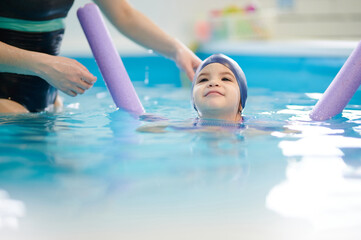 Obraz premium Swimming kid in pool with floater