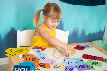 Little caucasian girl studying numbers and math in the classroom, stylish interior for home...