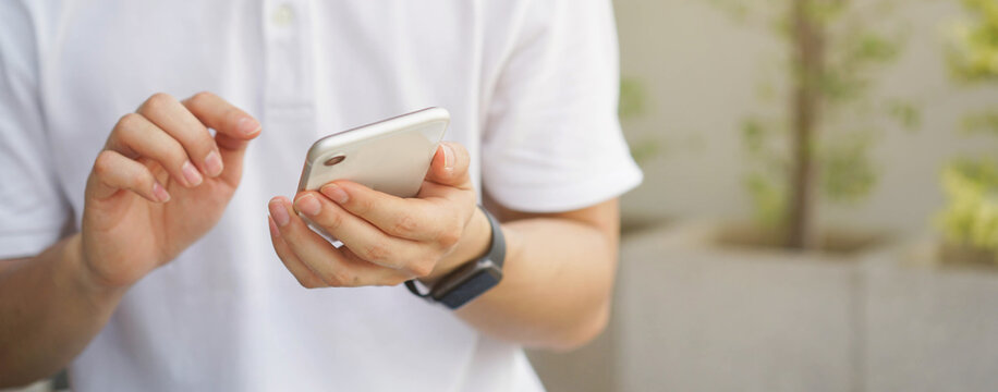 close up man hand hold mobile cell phone device for surf the internet or check news or play social media network  application in relax time concept