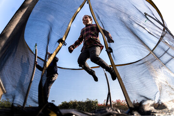Black children playing on trampoline