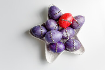 Dragon lilac easter eggs with 
easter decorations on a white star plate. White background. Copy space.