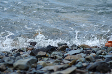 Sea surf. The incoming wave breaks on the coastal rocks creating an amazing splash of large drops.