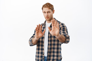 Please stop, stay back. Worried redhead man asking to keep distance, raising hands in prohibit, no...