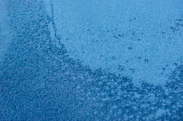 Icy texture on car windshield in winter