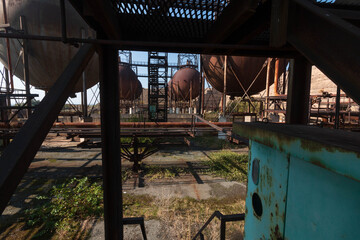Fototapeta na wymiar abandoned factory with rusty cisterns