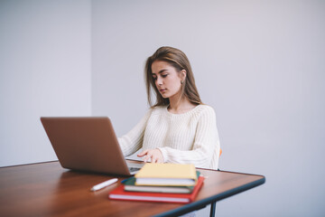 Thoughtful businesswoman preparing working place with laptop and copybooks
