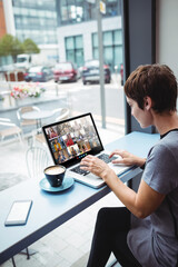 Asian businesswoman sitting at desk using laptop having video call