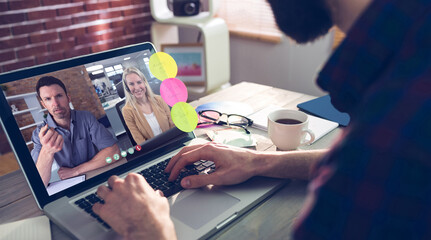 Caucasian man siting at desk, using laptop, having video call with coworkers