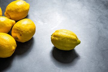 Several ripe lemons on a gray background