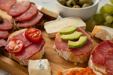 Assortment of sausages and cheese, salami, olives, on white background. Close up