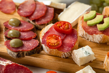 Assortment of sausages and cheese, salami, olives, on white background. Close up
