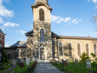 Fototapeta na wymiar Kingston, NY - USA- May 12, 2021: The Old Dutch Church, a 19th-century bluestone church and cemetery located on Wall Street in the Kingston Stockade District.