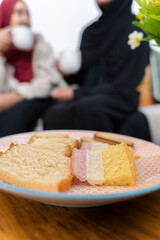 Two Black Muslim women having tea and cake